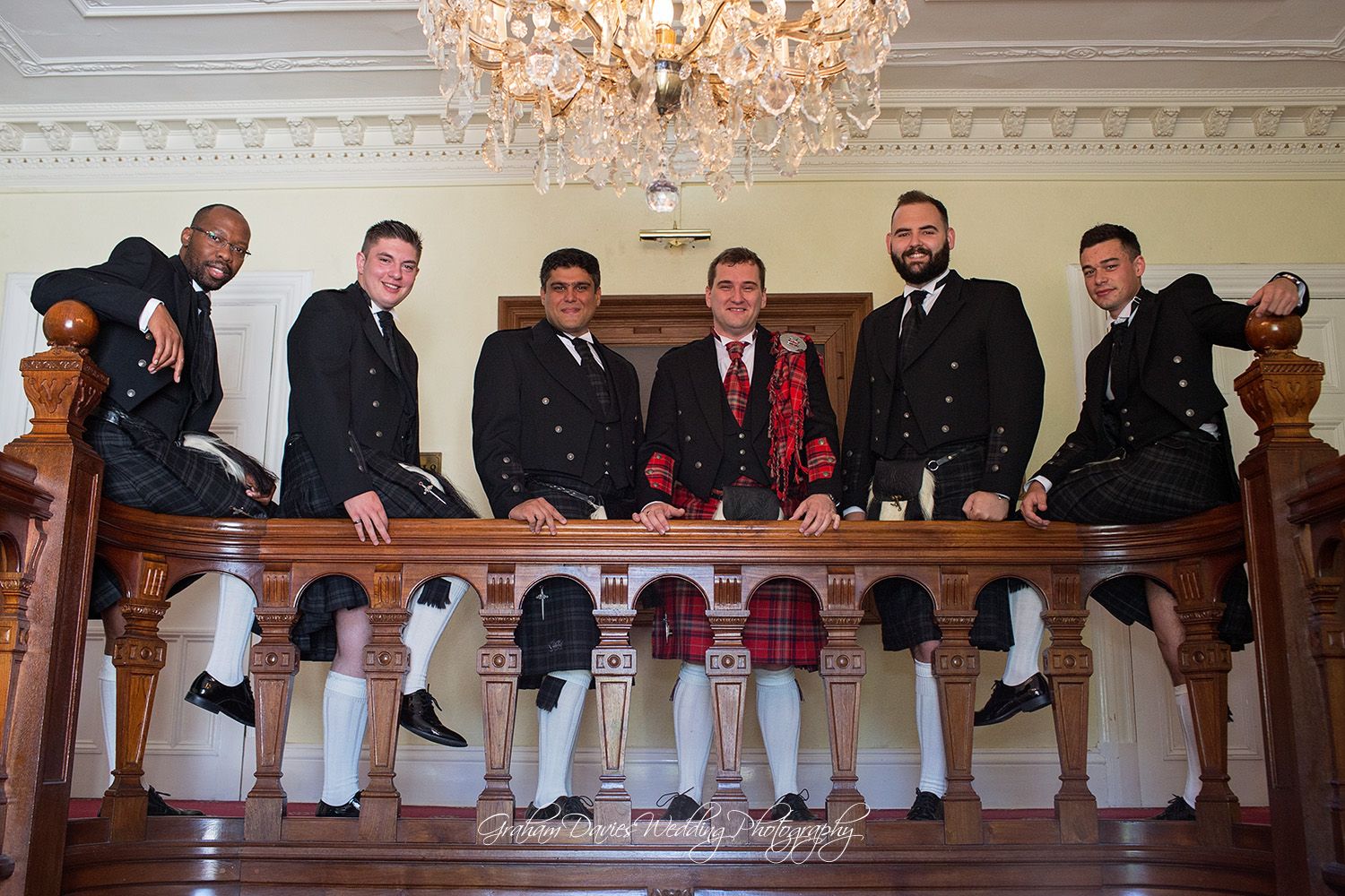 groom in his kilt with groomsmen on stairs at Court Colman