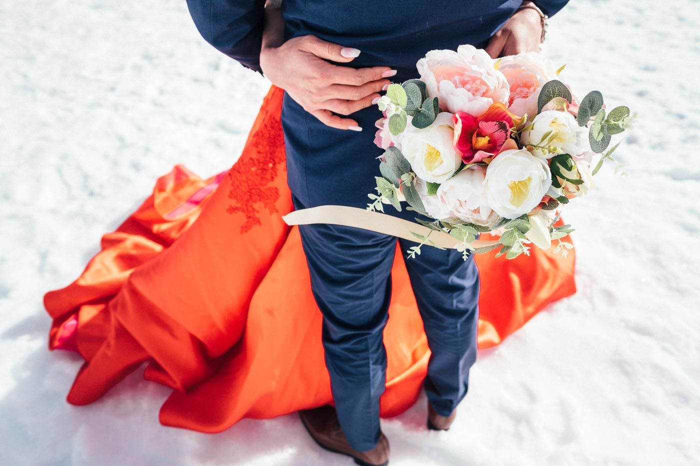 Elopement Bride holding her bouquet while she hugs the Groom
