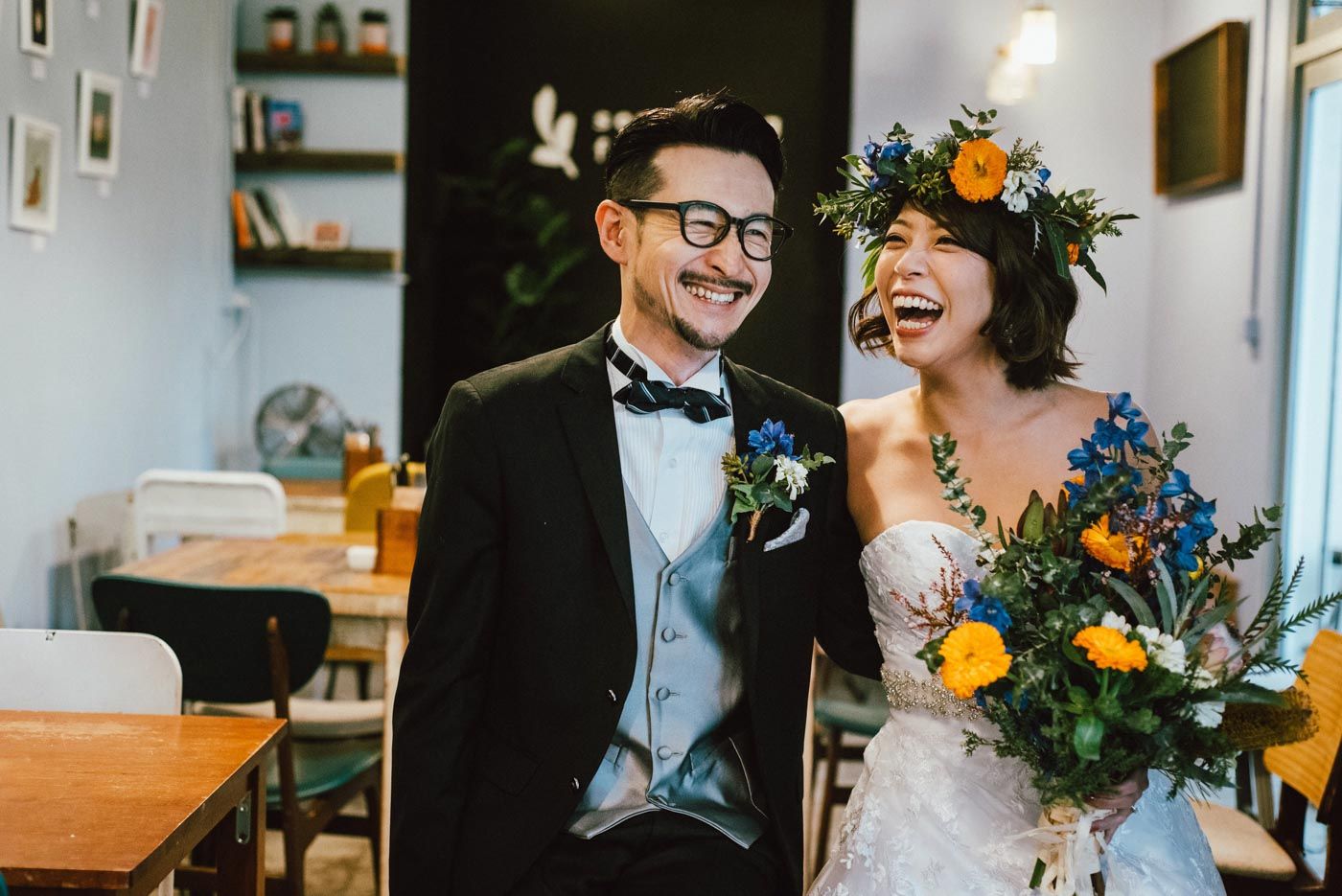 Elopement couple laughing together inside cafe