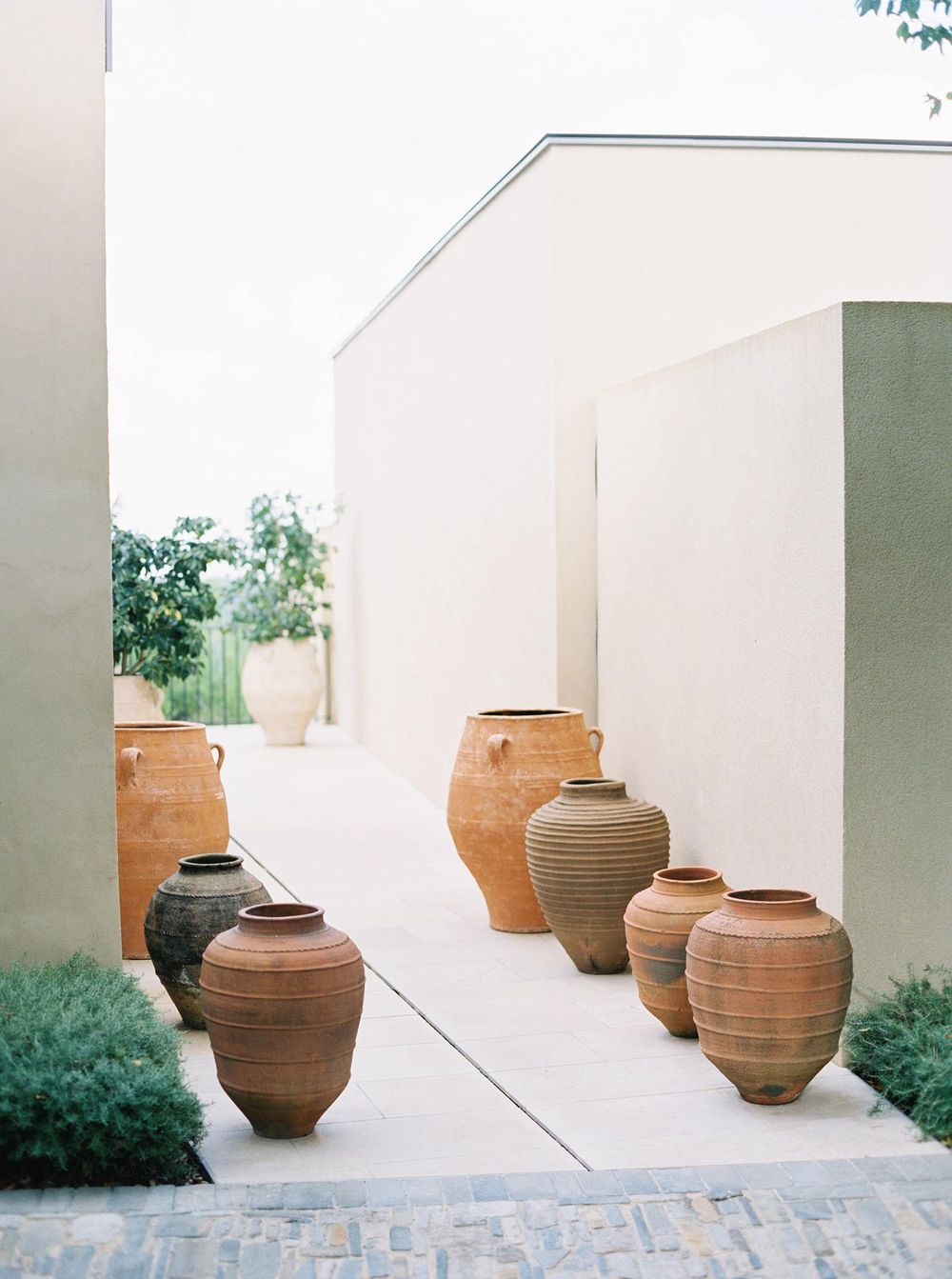 A collection of pots on a brick walkway at Villa La Coste, Provence.