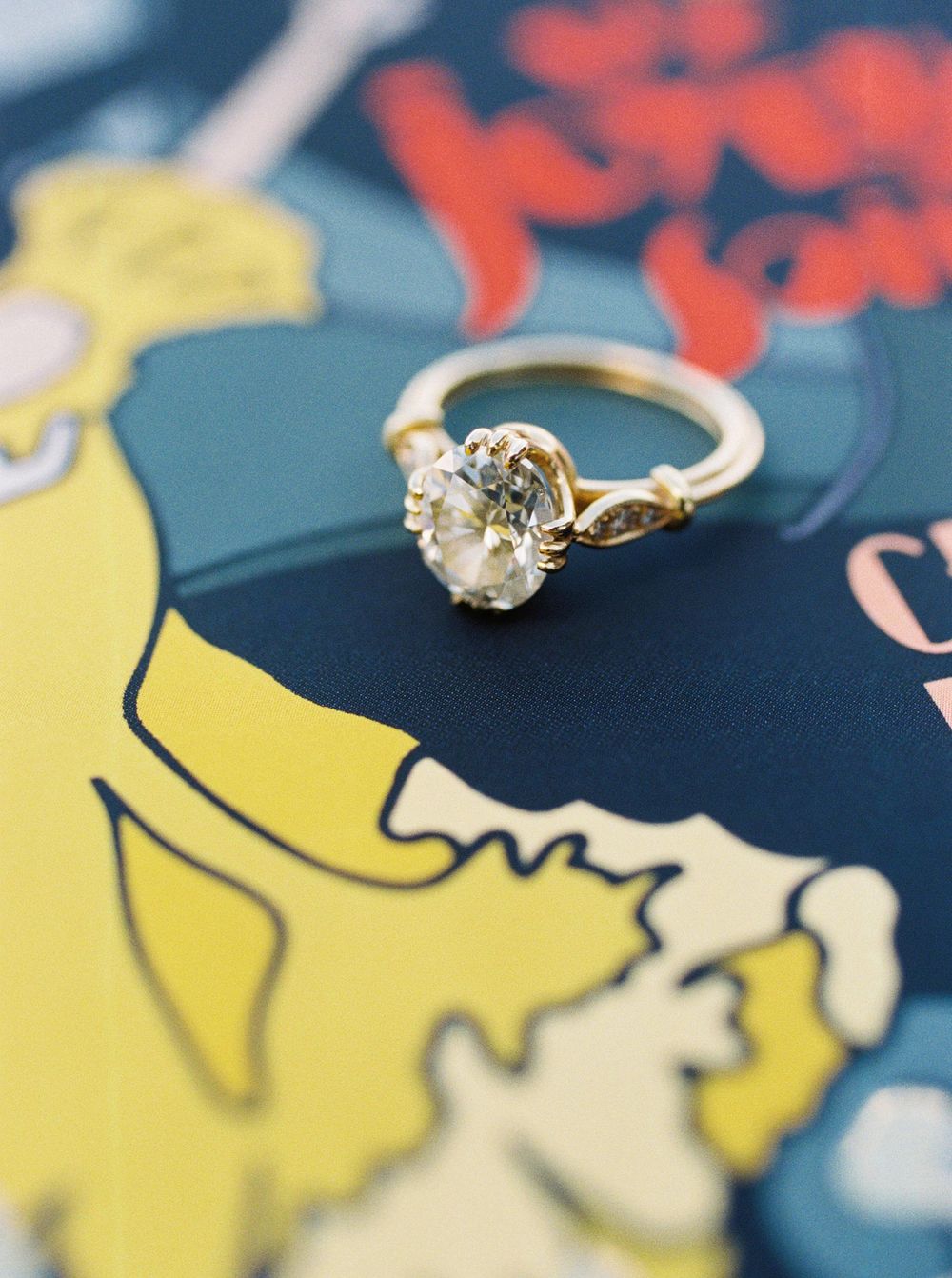 A yellow diamond engagement ring elegantly rests on a book, creating a captivating contrast.