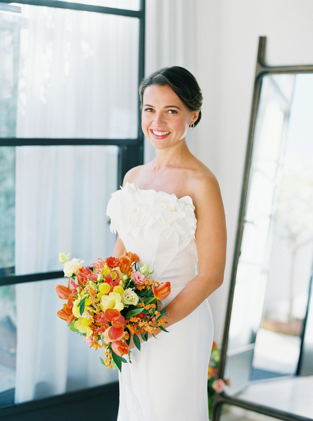 n elegant bride in a white dress with a bouquet of flowers at Villa La Coste, Provence.