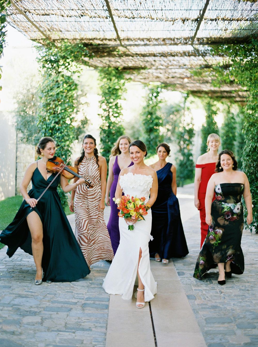 Bridesmaids in vibrant, long dresses posing at Villa La Coste, Provence, exuding elegance and style.