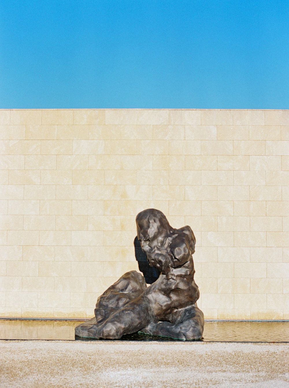 A statue of a man sitting on a rock in Villa La Coste, Provence.