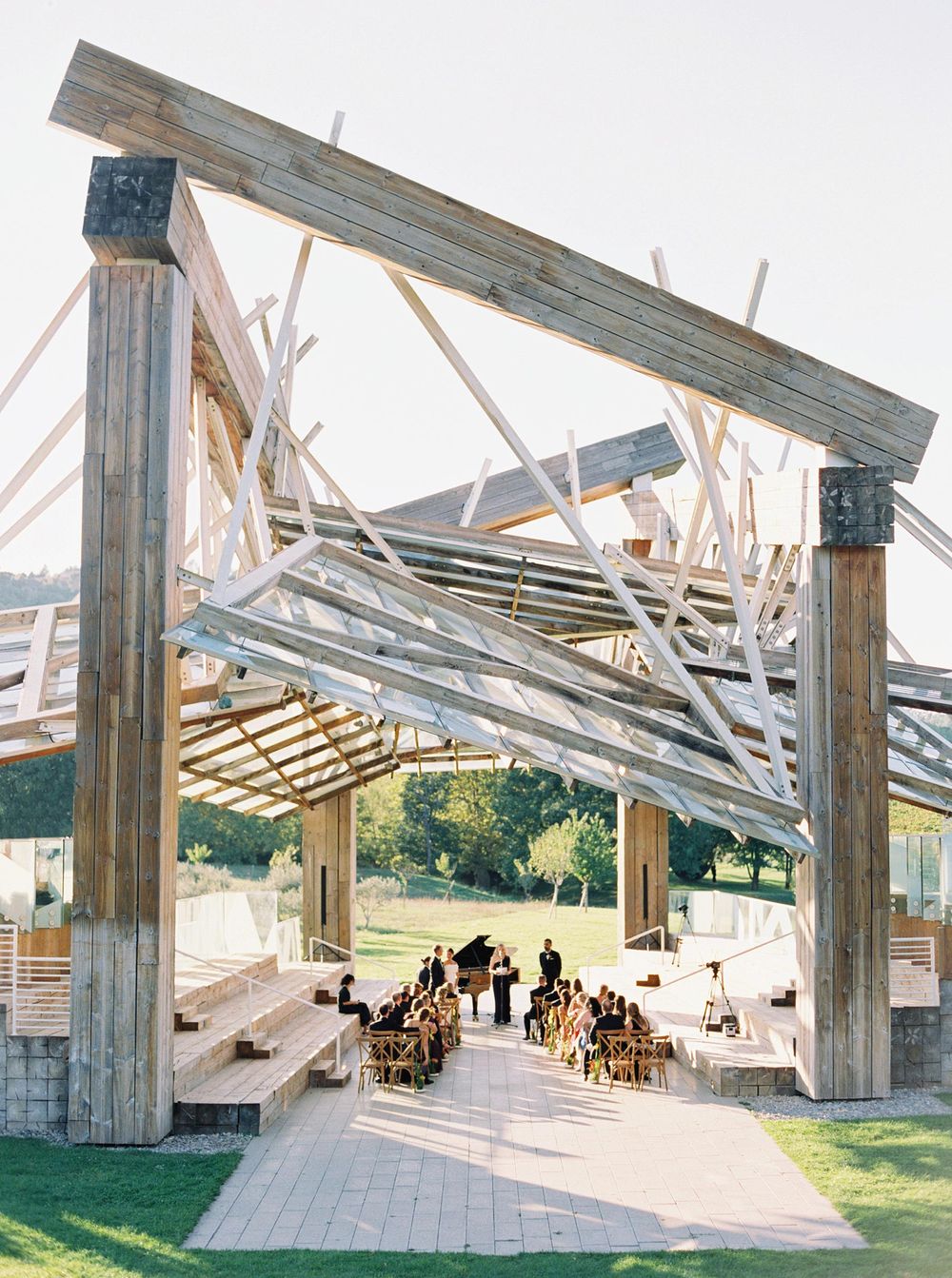 Outdoor wedding ceremony at Frank O. Gehry's Music Pavilion in Château La Coste, Provence - wooden structure.