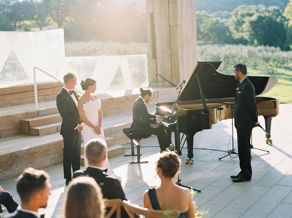 A beautiful wedding ceremony at Château La Coste, Provence, with a piano under the sun's warm glow.