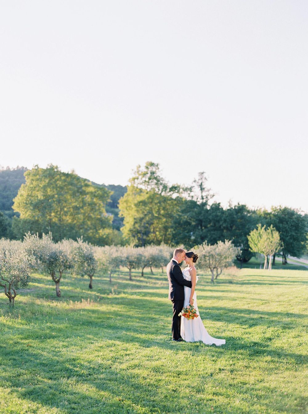 An enchanting moment at Château La Coste, Provence, bride and groom pose amidst he winery's scenic beauty.