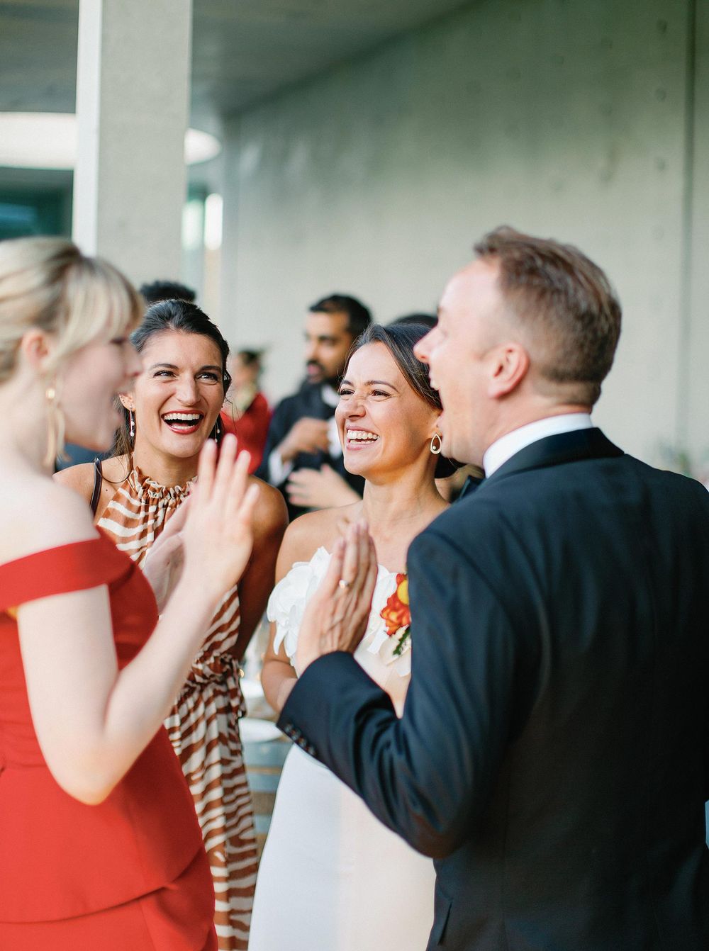 A joyful bride and groom share laughter with their friends at Château La Coste.