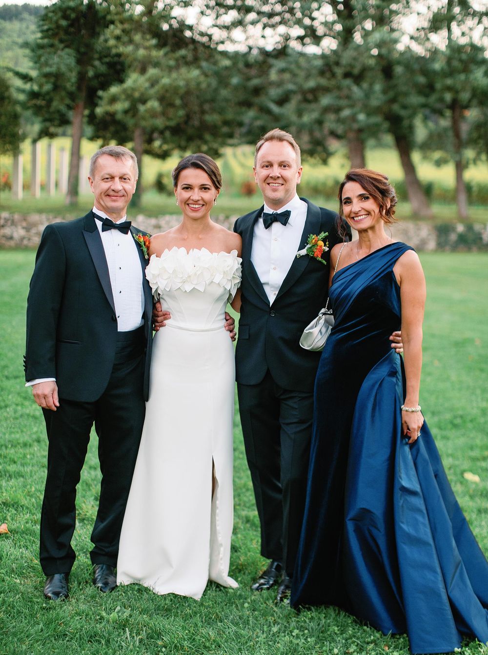 A family portrait featuring the bride and groom dressed in elegant attire.