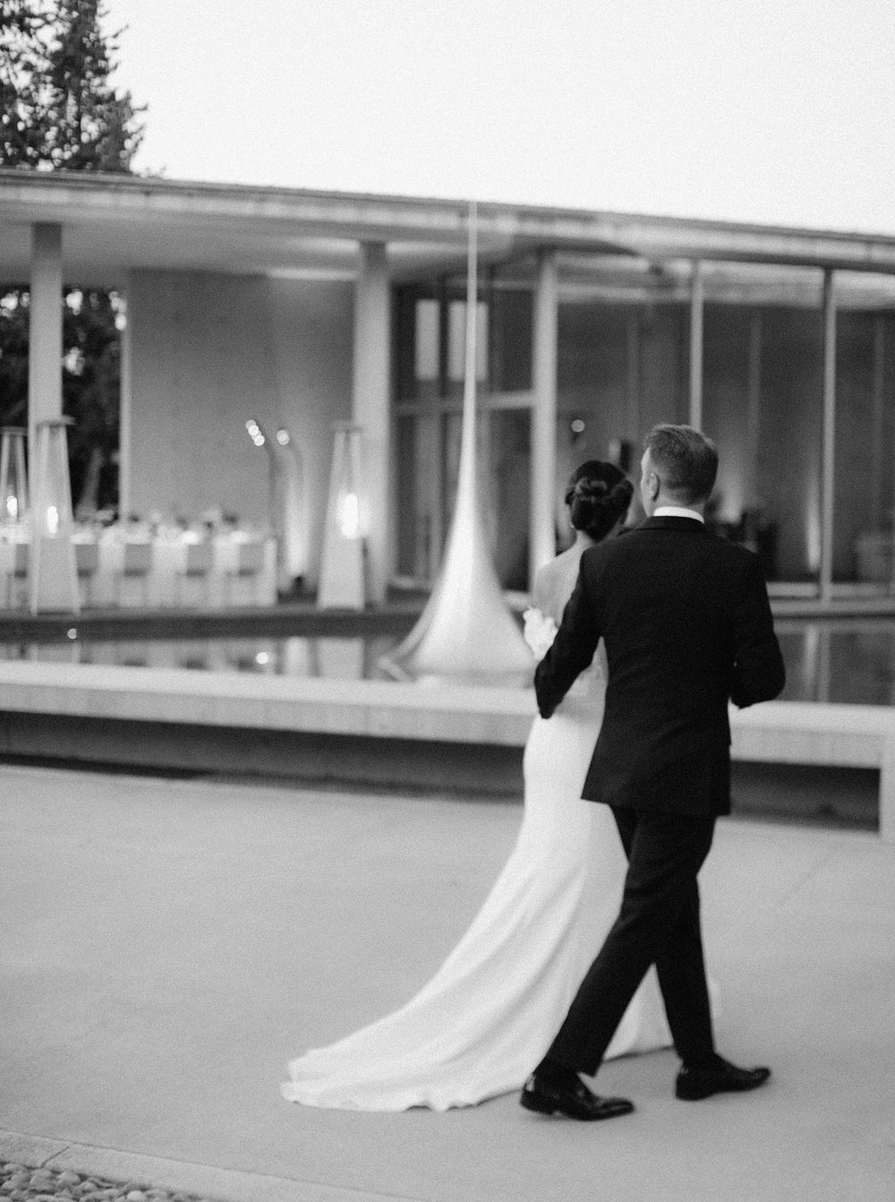 A newlywed couple strolling through a wedding courtyard, radiating joy and elegance on their special day.
