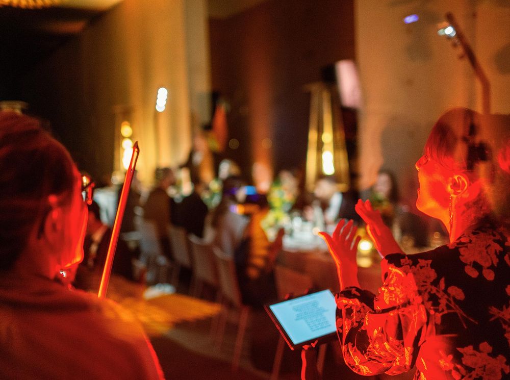 A violinist performing at a wedding reception, surrounded by other musicians.