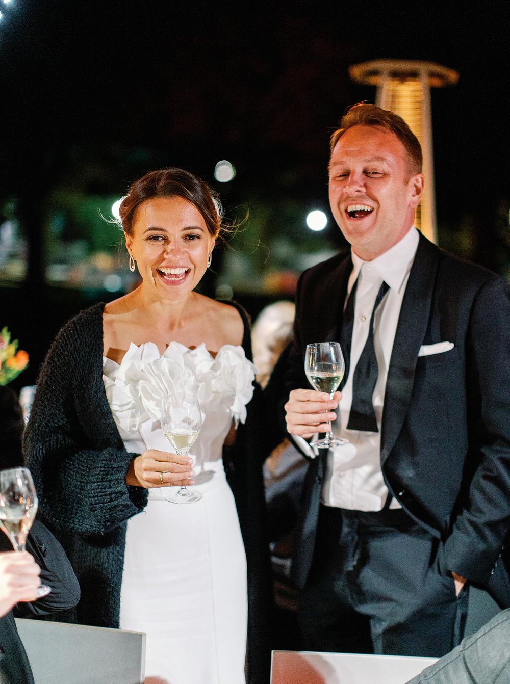 A joyful bride and groom share laughter during their wedding reception, creating cherished memories.
