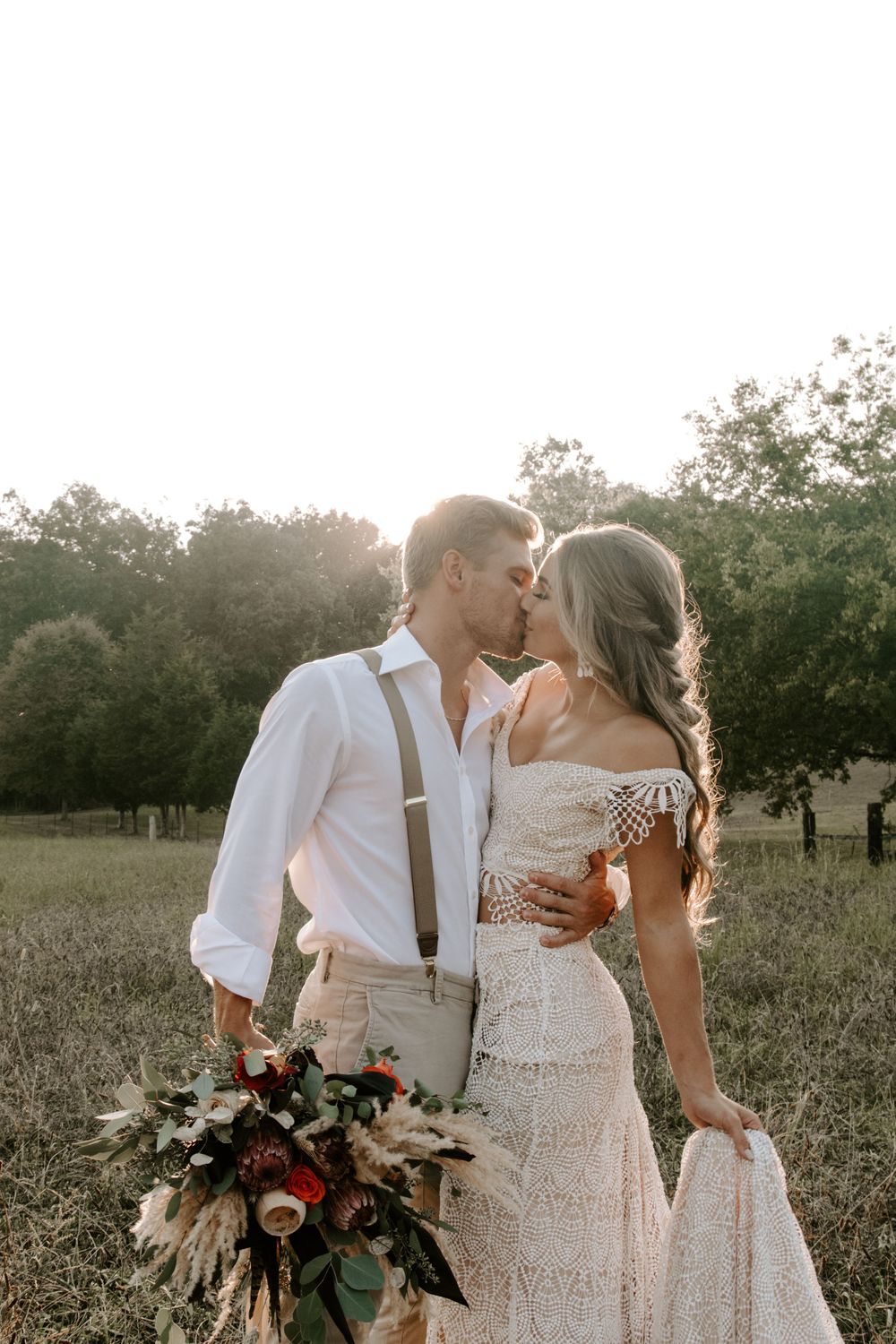 couple standing face to face sharing a kiss as the man is holding the bouquet during their Smoky Mountains elopement