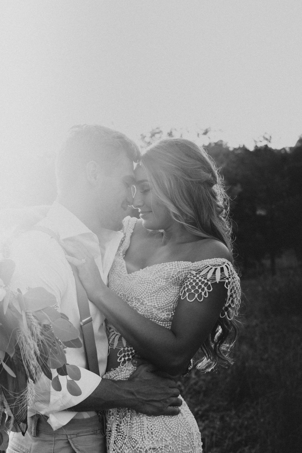 couple standing forehead to forehead with the sun setting in the background during their Tennessee wedding
