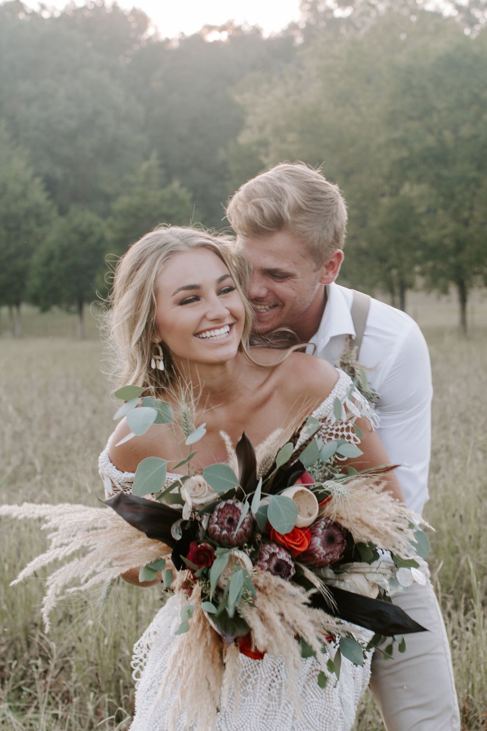 man hugging his new wife from behind as they are both smiling during their Mountain elopement