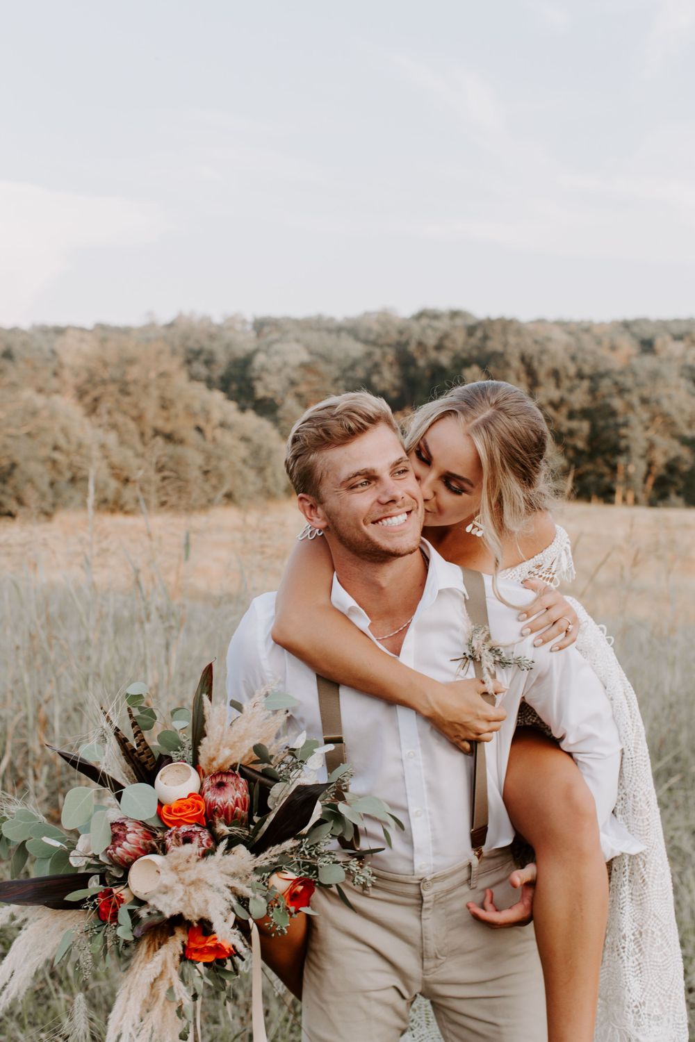 woman getting a piggy back ride and kissing her partner on the cheek as he is smiling