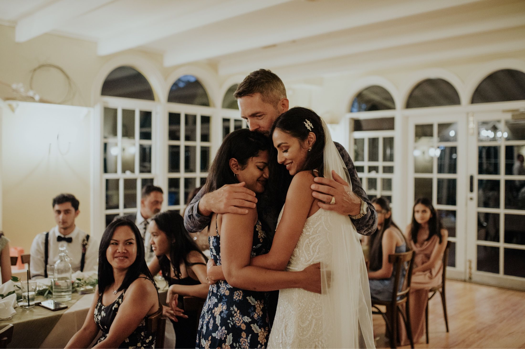 Groom hugs bride and her best friend after her speech at wedding reception in Fortnums Sassafras