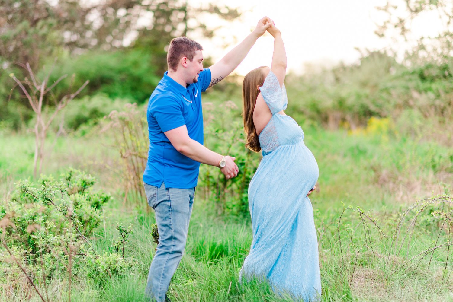 Maternity session with couple dancing in field in golden hour sunlight at Moraine State Park, Pennsylvania