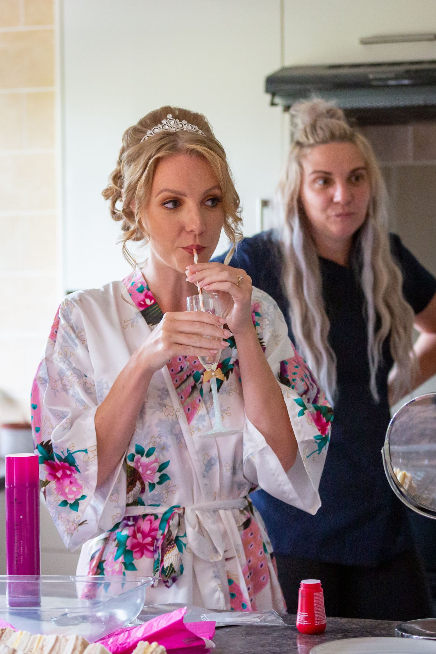 By drinking champagne from champagne flute through a straw while getting ready on the wedding morning