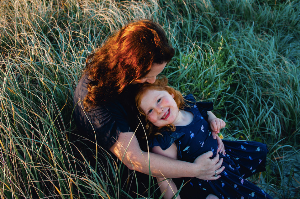 mother and daughter at sunset long grass
