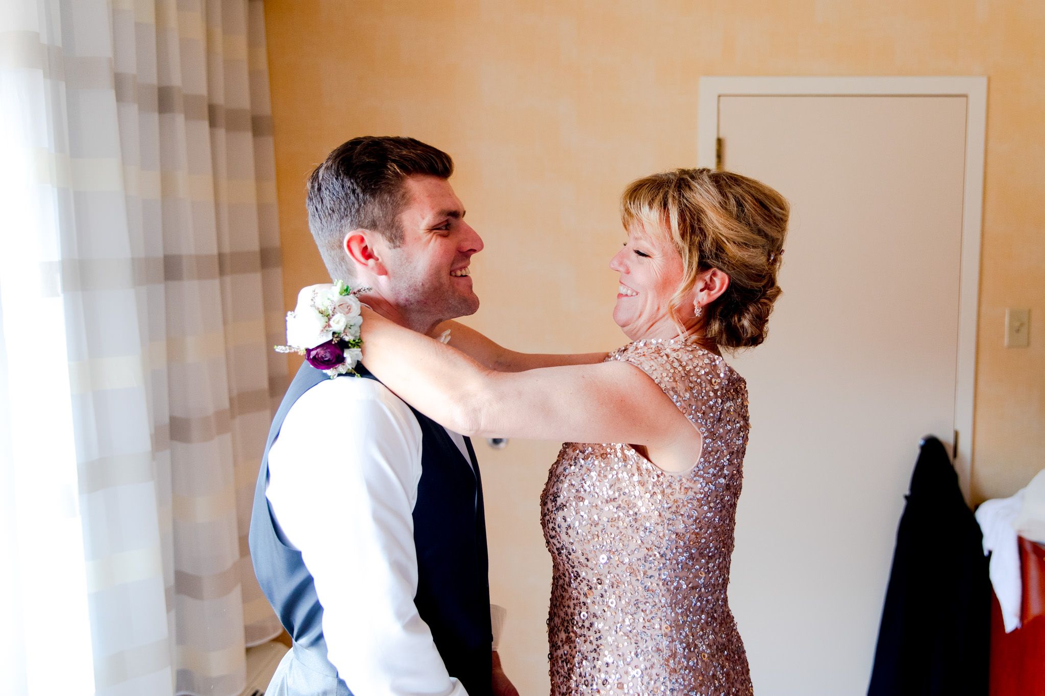 groom wearing black vest smiles before his chicago wedding