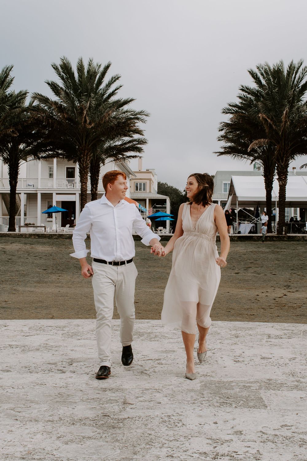 couple holding hands running trough Seaside Florida