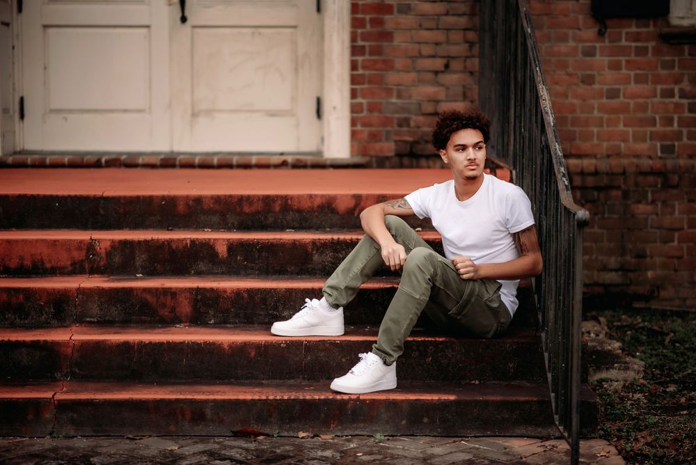 High School Senior Photo of a boy sitting on red steps