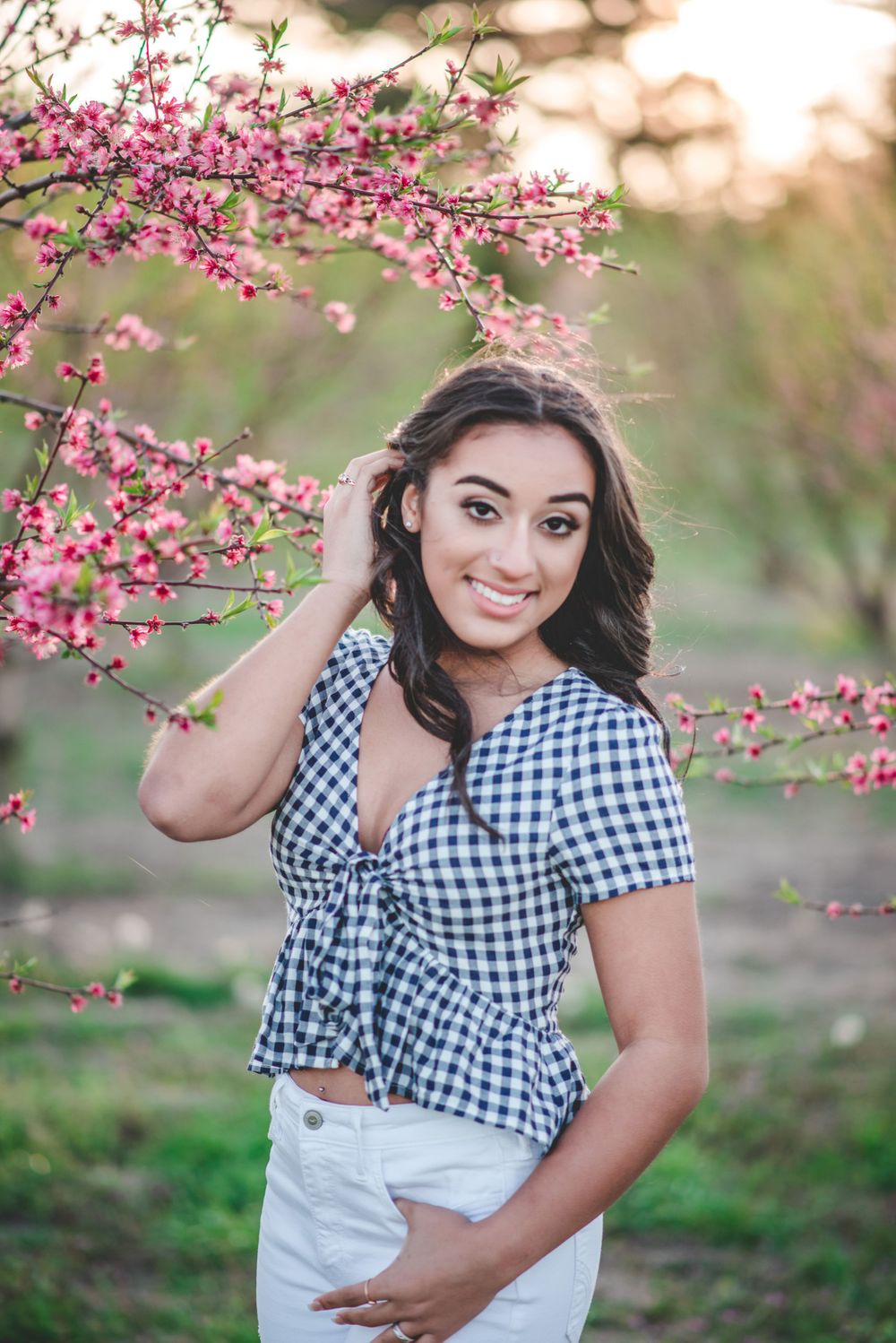 High School Senior Photo of a girl standing in front of a blooming pear tree