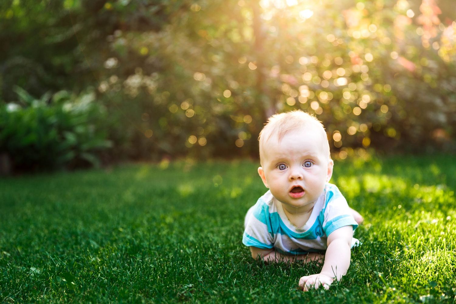baby girl laying on green grass in the summer