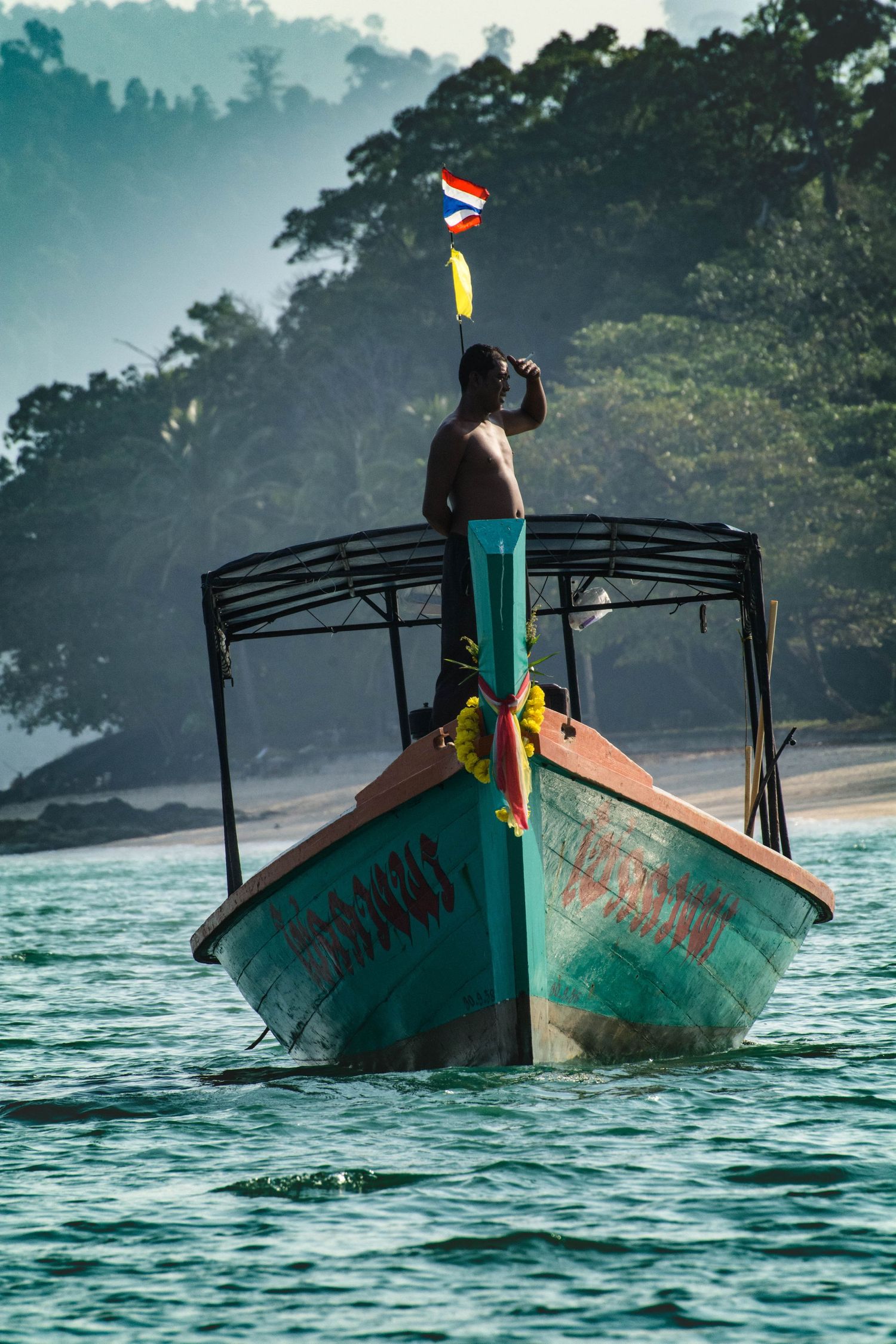 Boats captain stand look out from prow on Andaman sea in Thailand