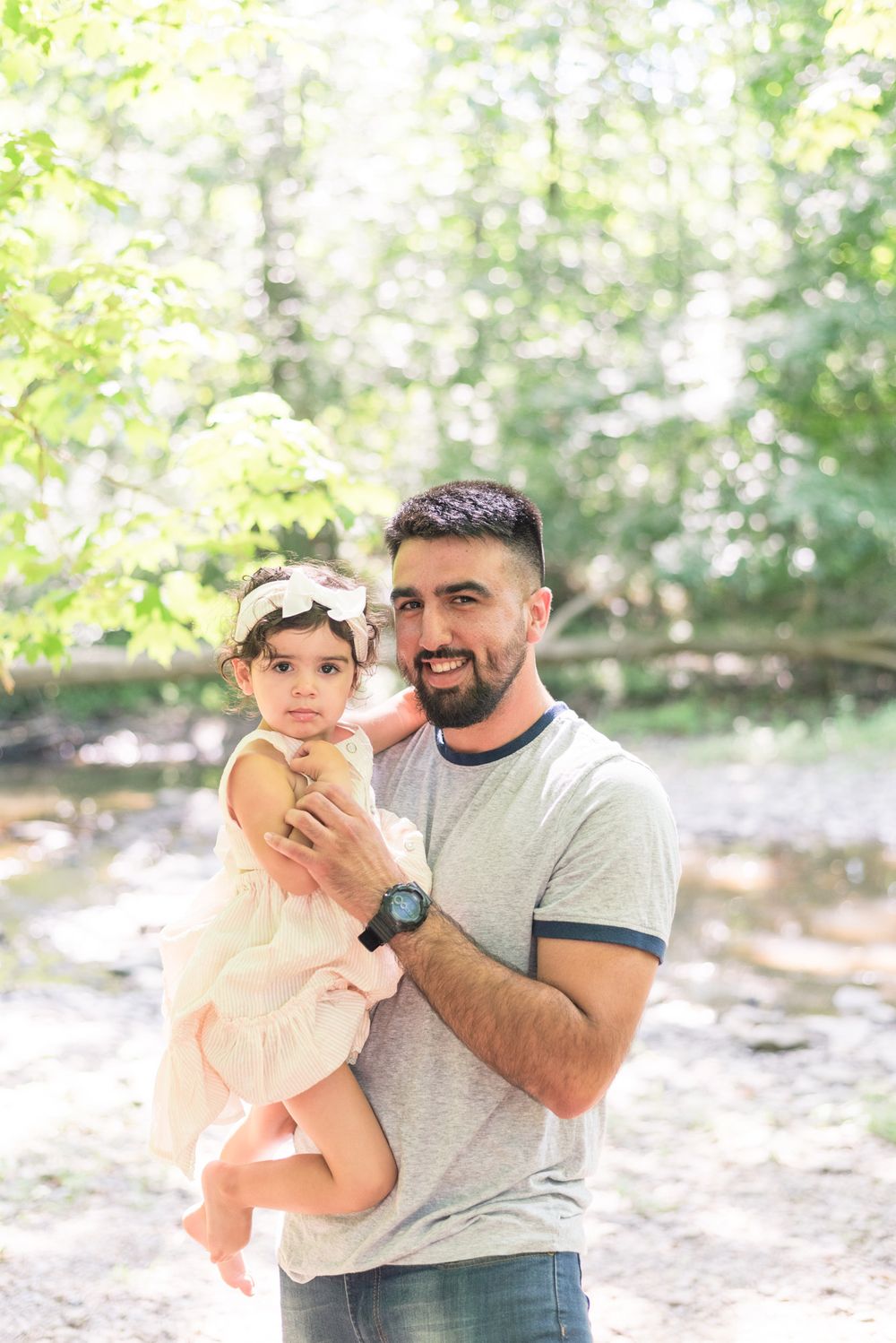 Dad holding toddler in creek in Pittsburgh, Pennsylvania