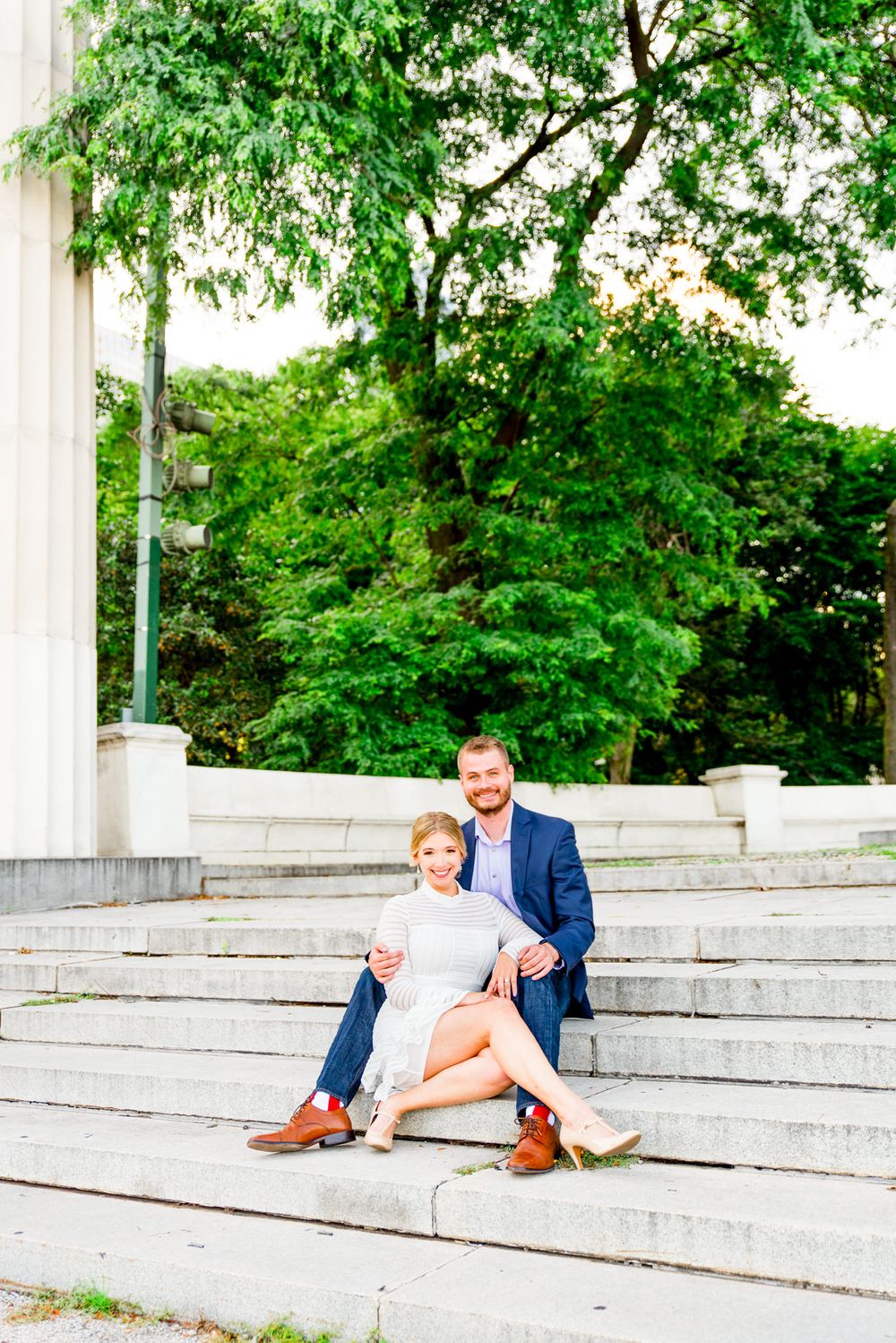 young engaged couple in Chicago sits on steps in Millennium Park