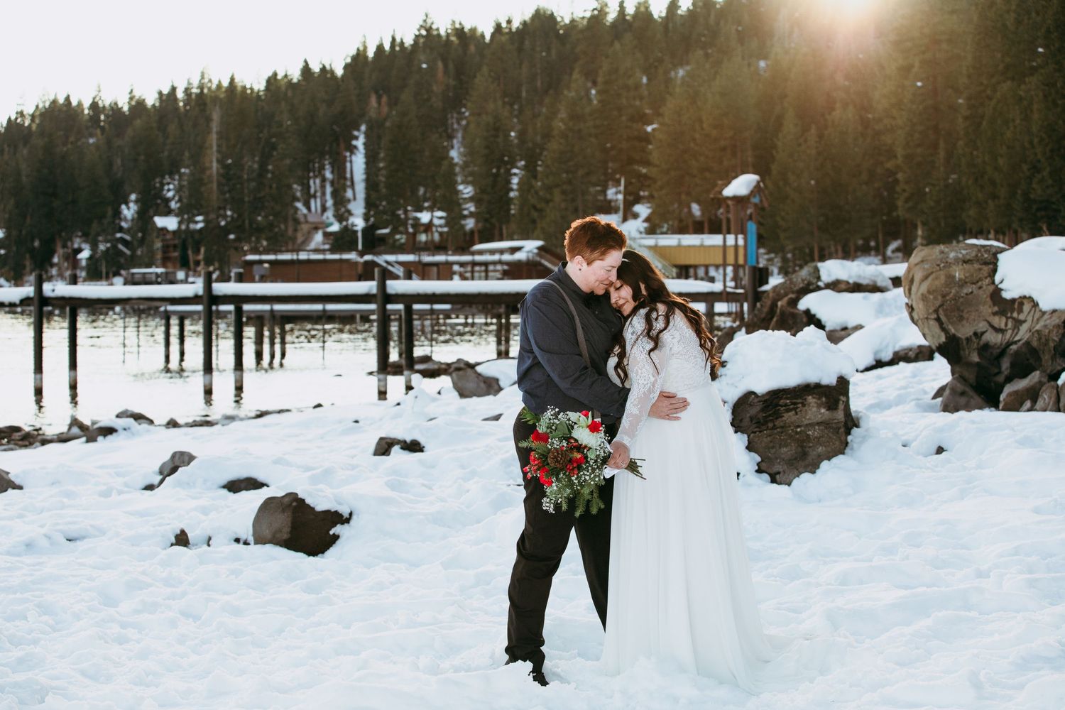 Brides embracing on the snow covered shores at Garwoods Lake Tahoe California elopement