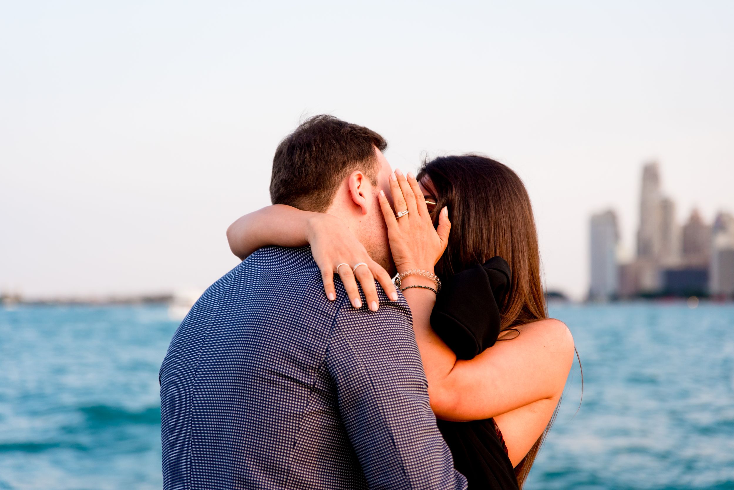 man and woman kissing after Chicago proposal at North Avenue Beach pier