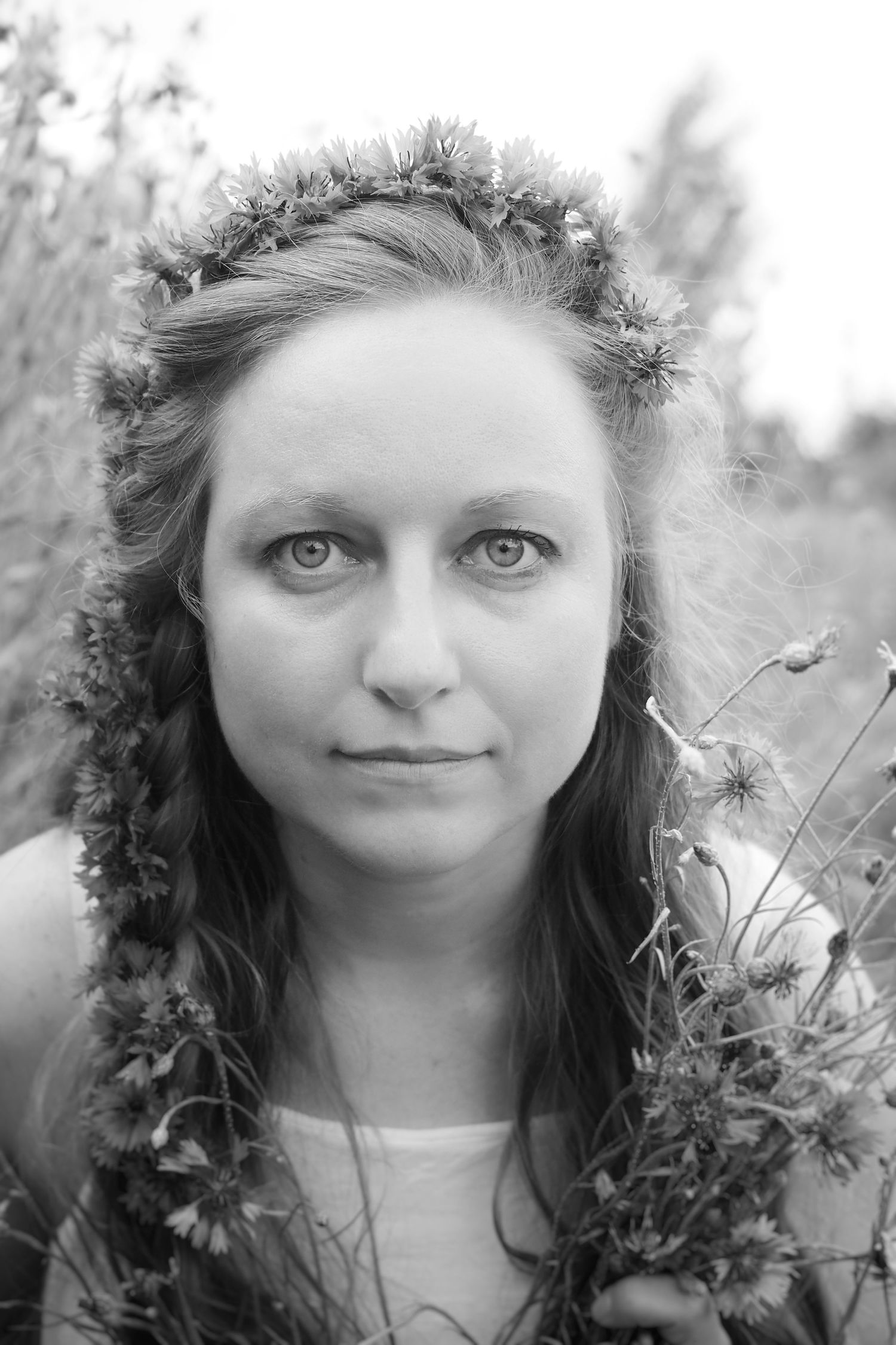 Black and white photo of a young woman with flowers in her hair