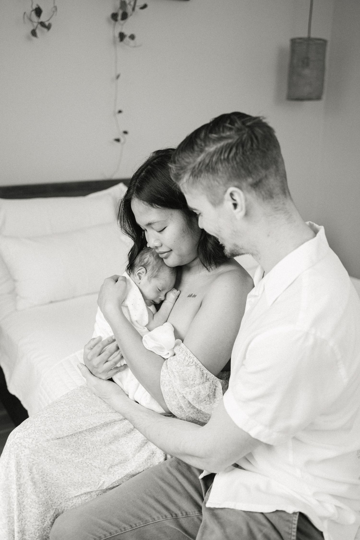 Black and white intimate portrait of parents with newborn.