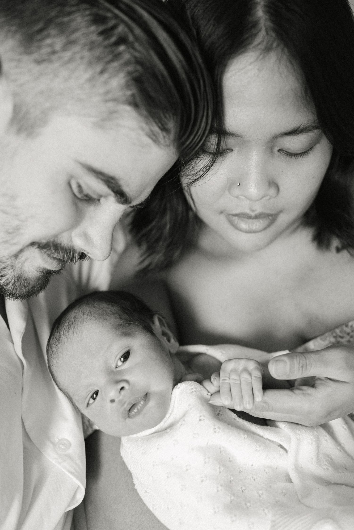 Black and white intimate family portrait showing tender care and connection.