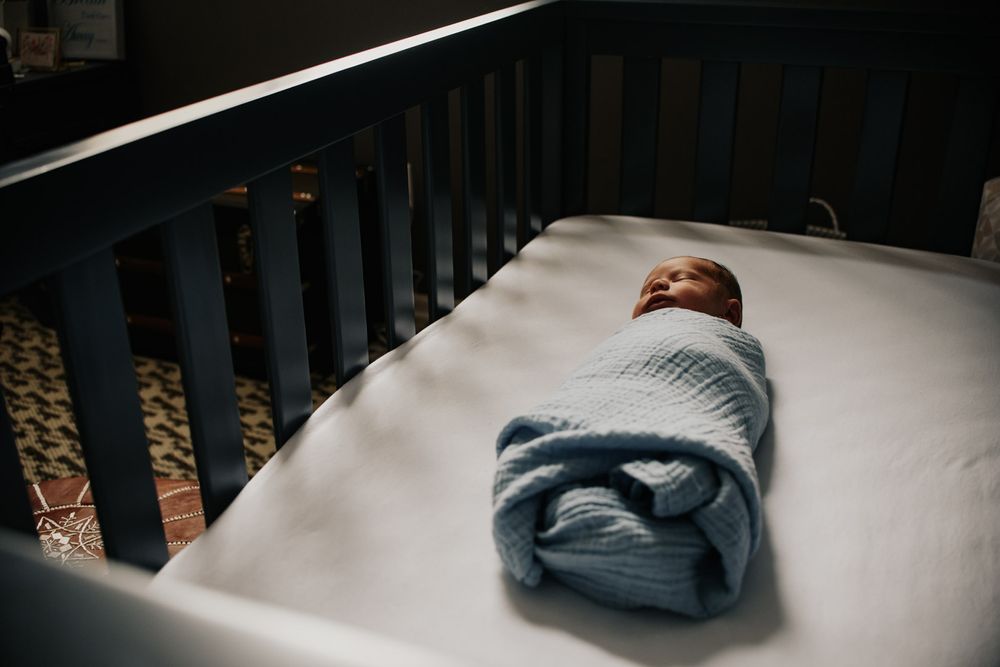 Vanourny Newborn Session Lifestyle Kansas City Photography swaddled newborn baby boy laying in crib