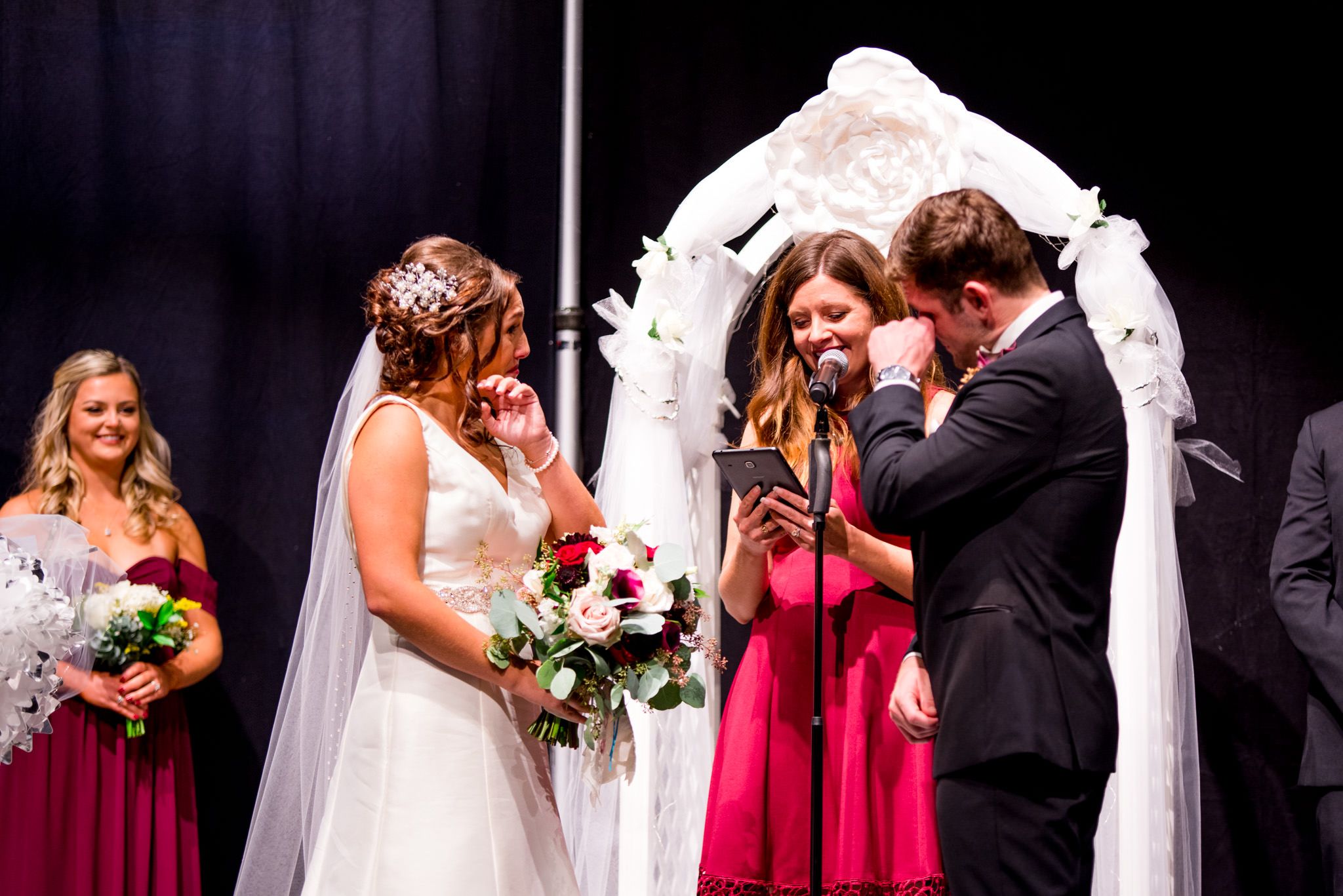 chicago couple wipes tears on fall wedding ceremony under white arch