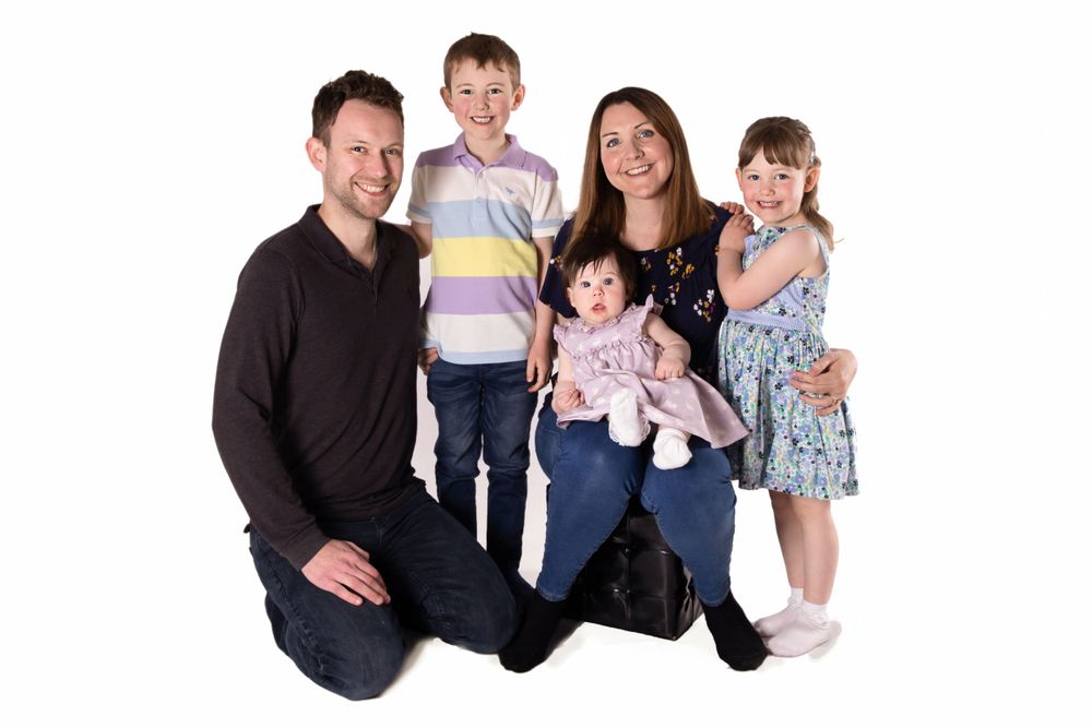 mum and dad kneeled on floor with son and baby girl