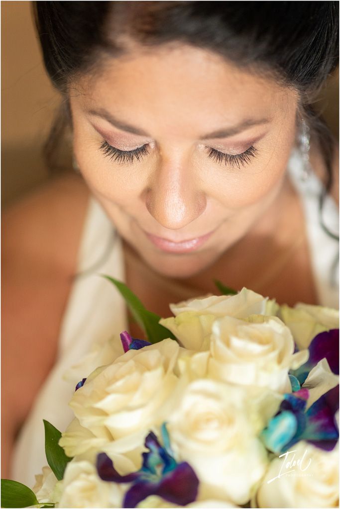 Close-up view of a bridal bouquet with white roses and blue orchids.