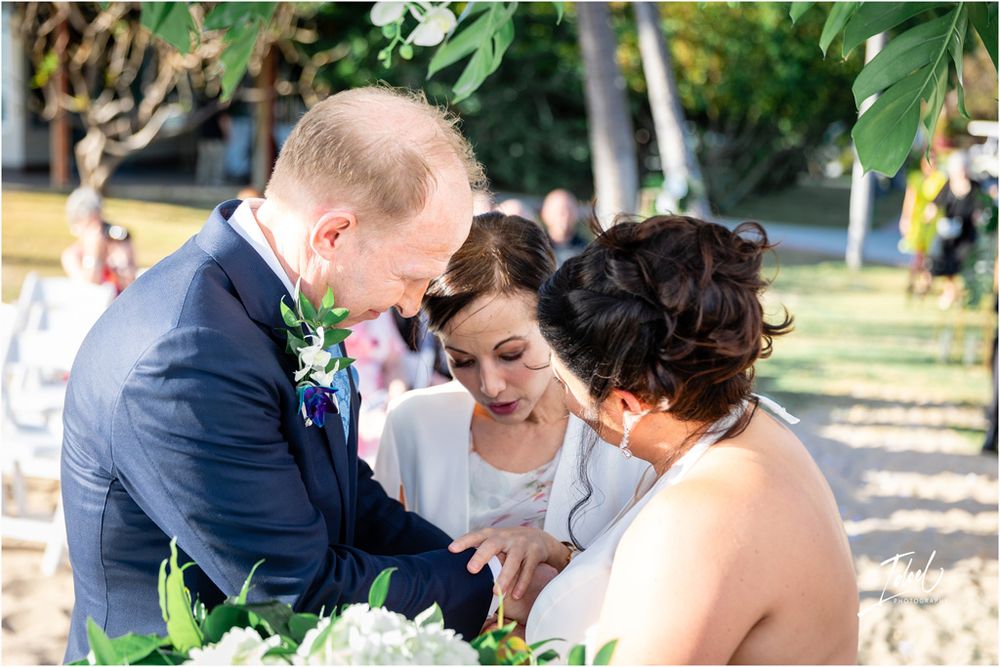 A tender moment shared between wedding participants during an outdoor tropical ceremony.
