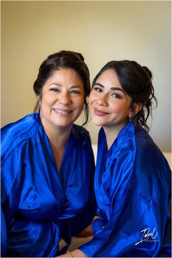 Two people wearing matching royal blue robes posing together before wedding.