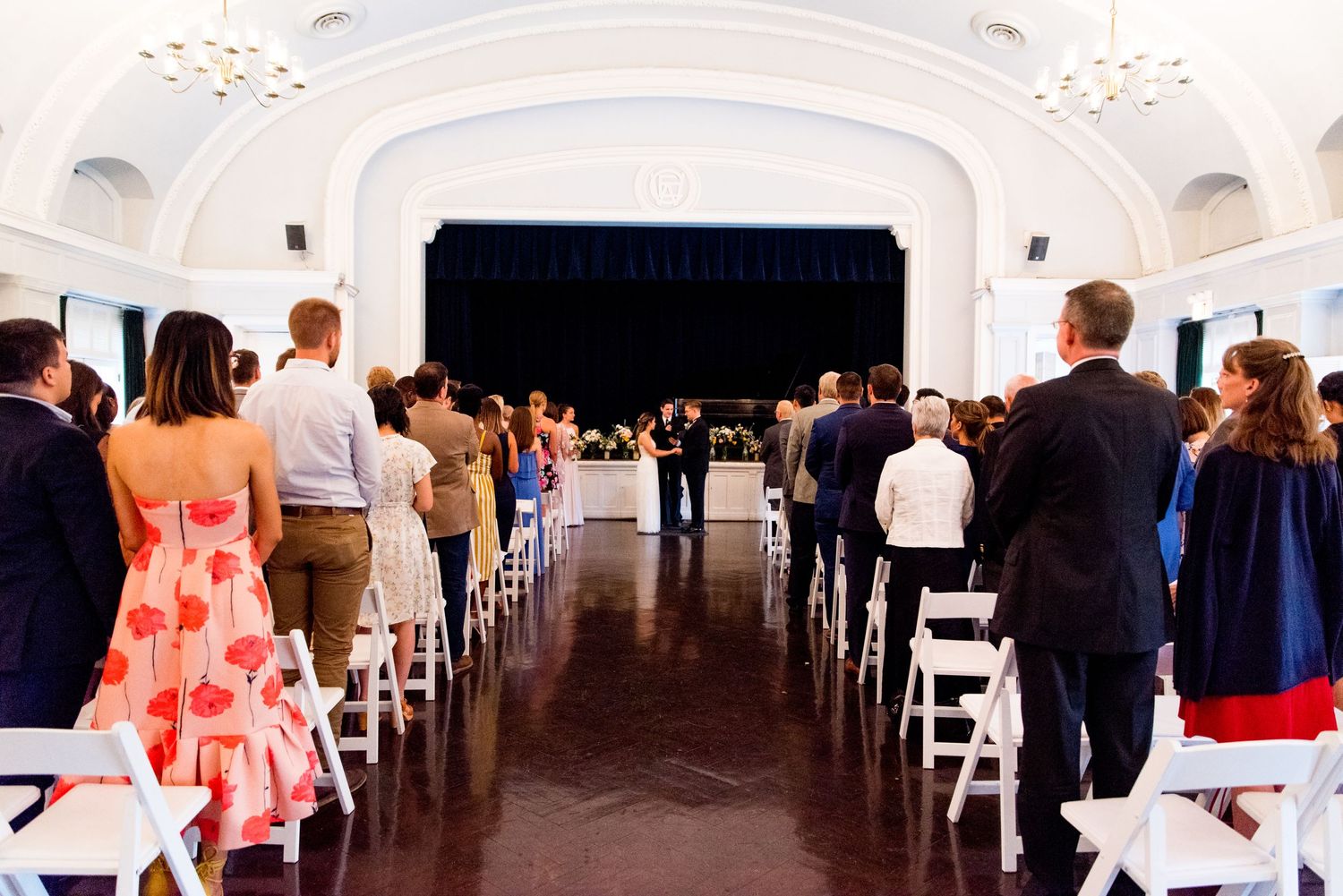 bride and groom hold hands in front of wedding guests at Woman's Club of Evanston