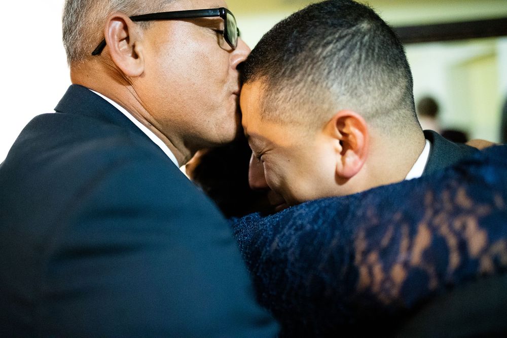 Groom cries as he is being hugged by his family by Hudson Valley photographer