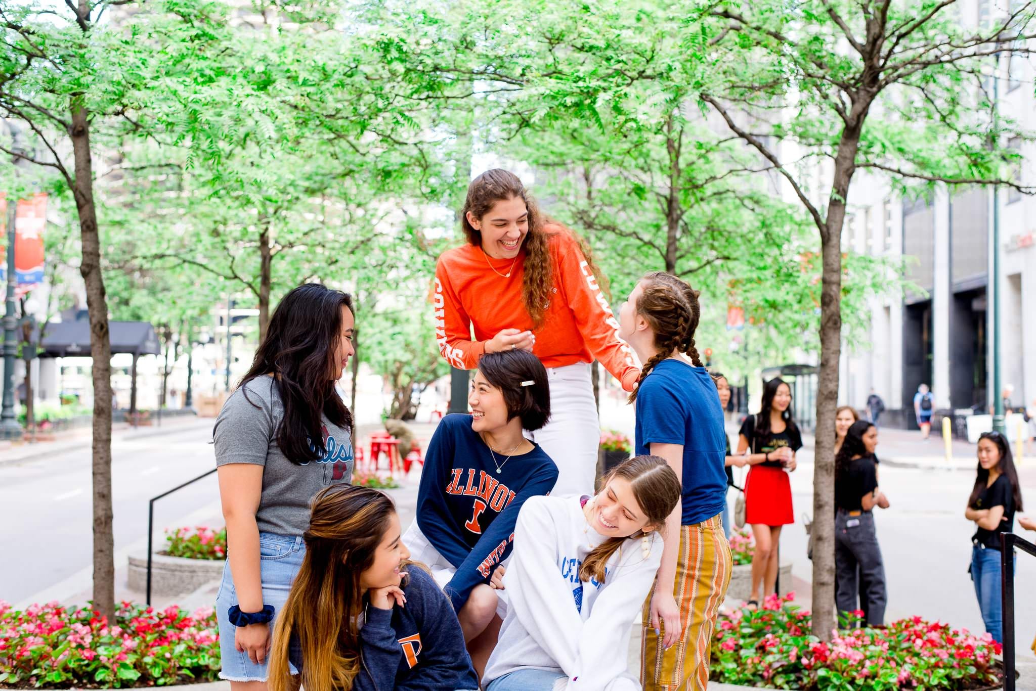 six young women laughing at each other in the street for Chicago senior pictures
