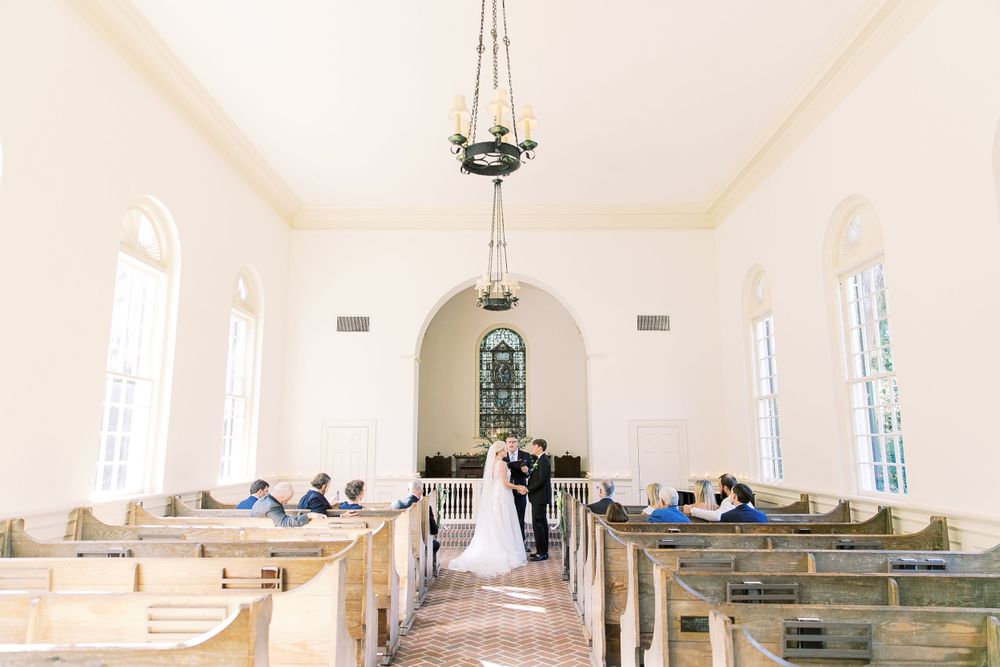 bride and groom stand at the front of the chapel during their wedding ceremony