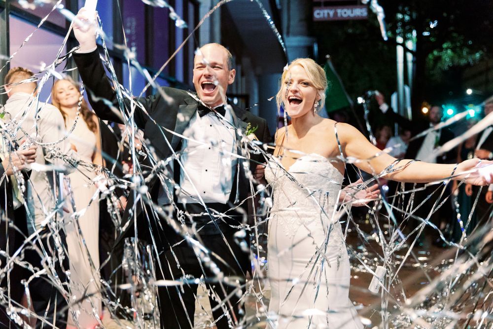 bride and groom celebrate their wedding day under streamers
