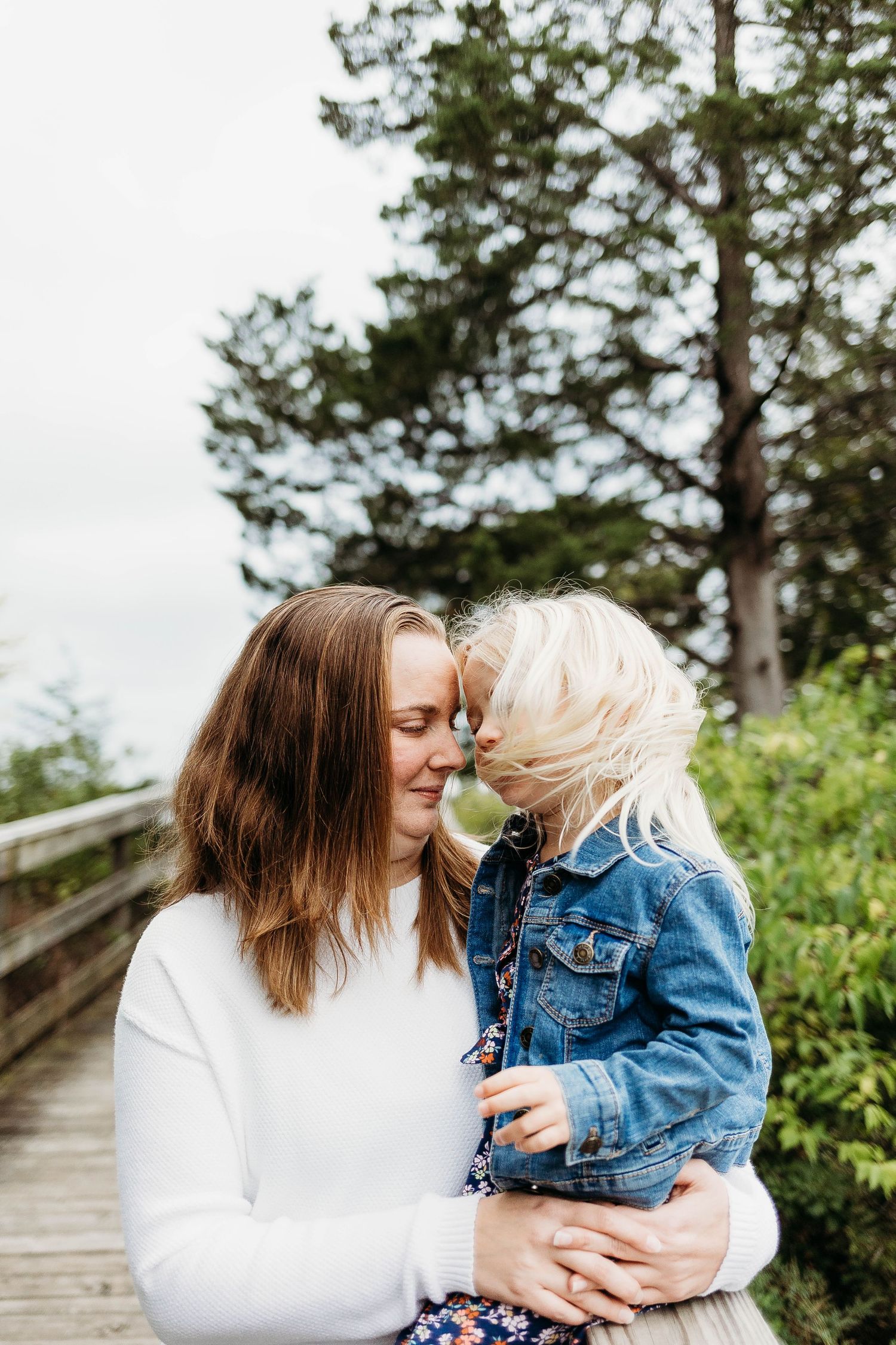 Mom and daughter place forward to forward while taking family photos in nagawicka park delafield, wisconsin