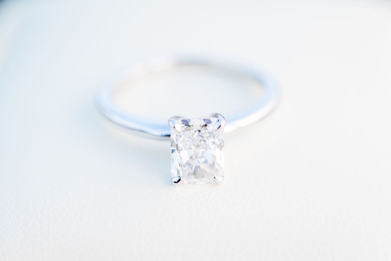 rectangle diamond and white gold engagement ring on top of white ring box by Chicago proposal photographer